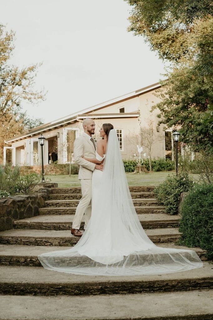 Bride and groom standing together on concrete steps outside