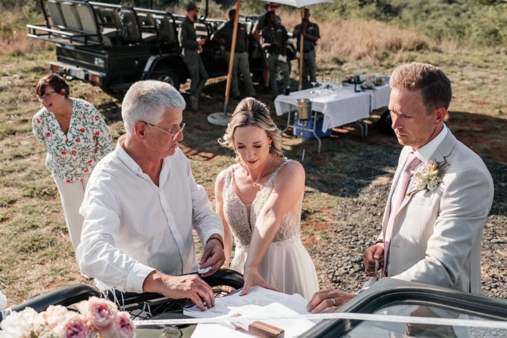 Bride and groom signing the marriage registry on top of game vehicle