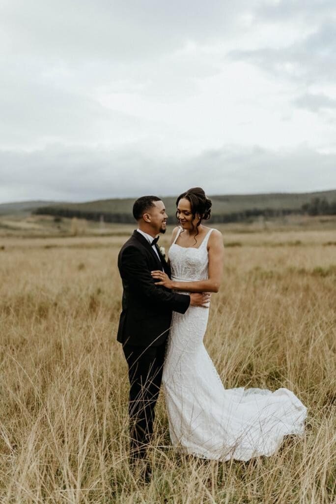 Bride and groom standing in grass field at Highgate Wine Estate