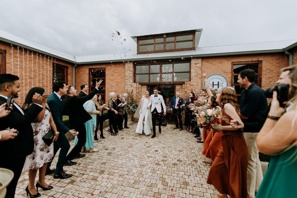 Bride and groom exiting Highgate Wine Estate venue with confetti toss