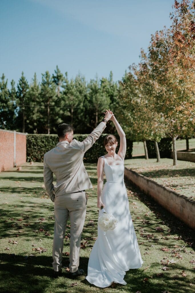 Bride being twirled by her groom in manicured gardens at Highgate Wine Estate
