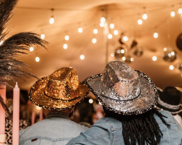 View from the back of 2 guests wearing glitter cowgirl hats