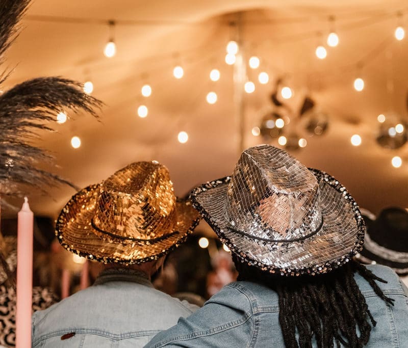 View from the back of 2 guests wearing glitter cowgirl hats