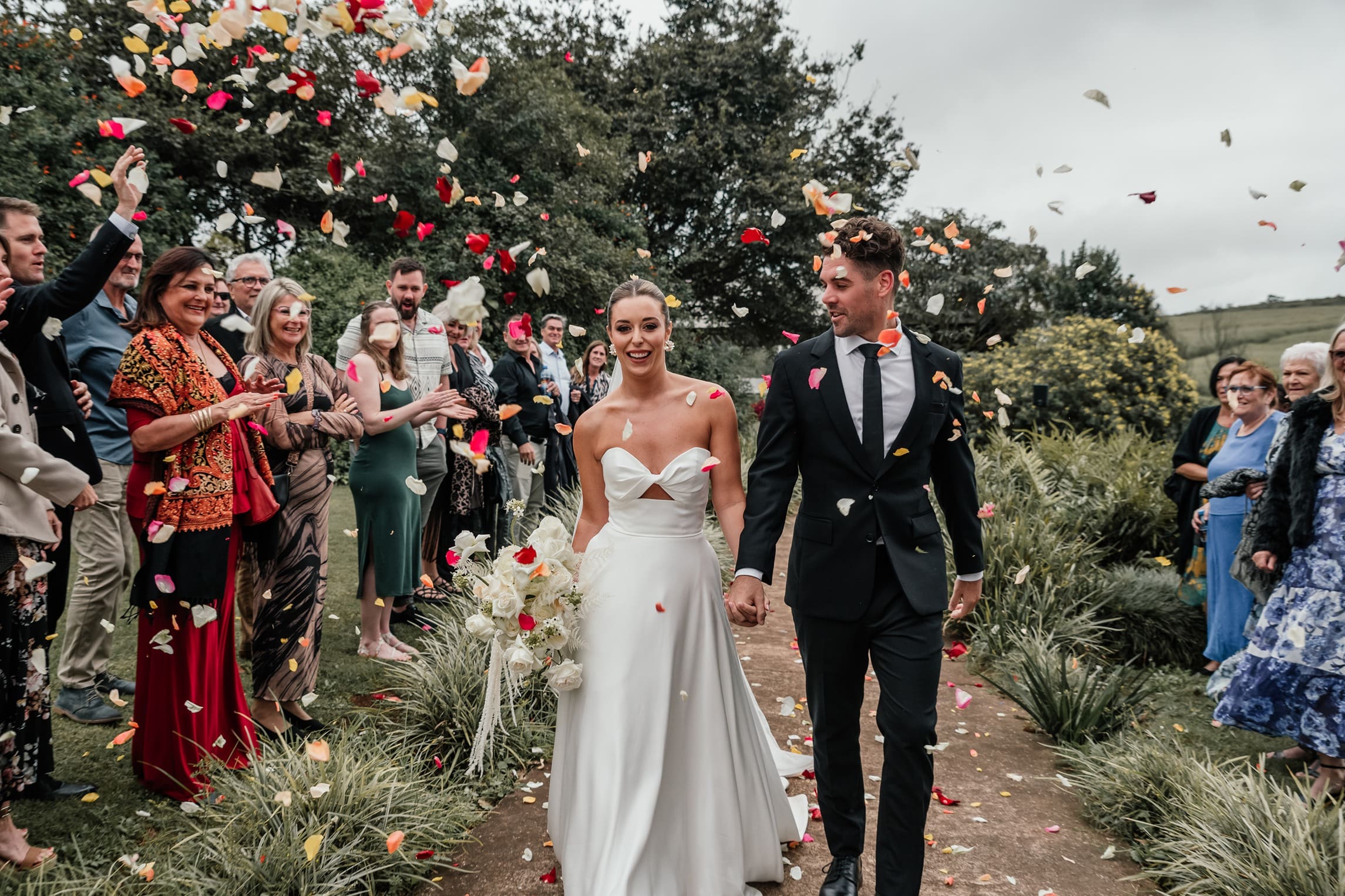 Colourful petal confetti being thrown at newlyweds at Sweethome