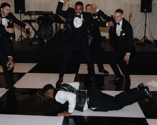 Groomsmen breaking it down on a checkered dance floor hired from Something's Borrowed.