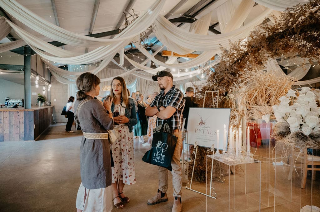 Guests to wedding showcase chatting to floral artist
