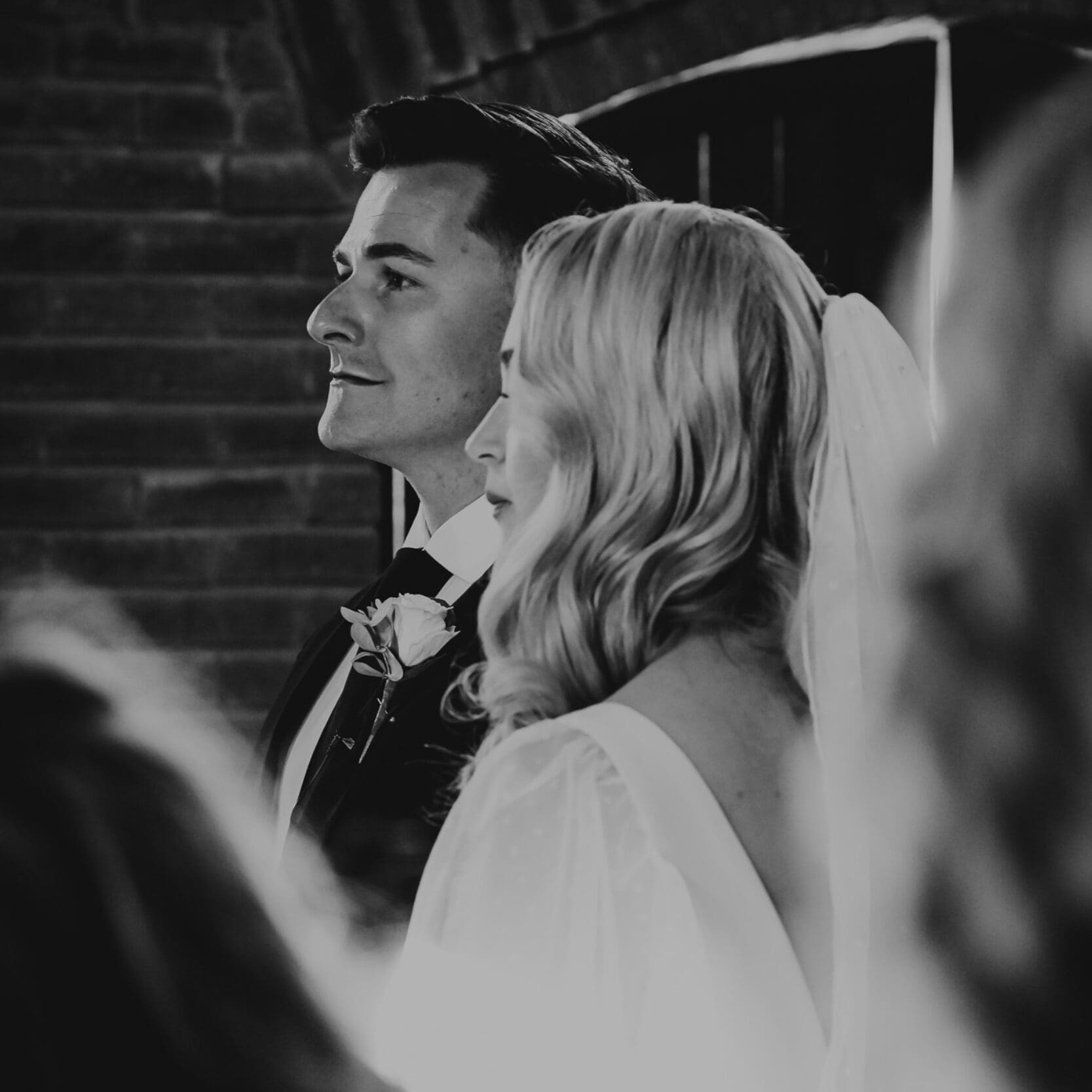 Black and white photo of bridal couple during wedding ceremony